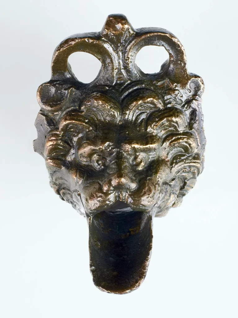 Vetrina L n. 5, attacco di ansa in bronzo con estensione a forma di testa leonina (IV secolo a.C.)