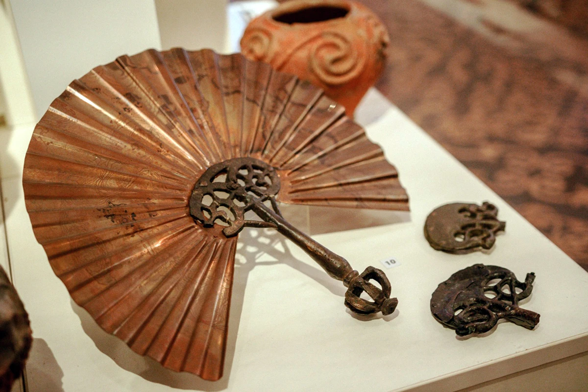 vetrina B, Veduta del settore dei ventagli e manico di bronzo con il ventaglio in rame di ricostruzione moderna (VII secolo a.C.)